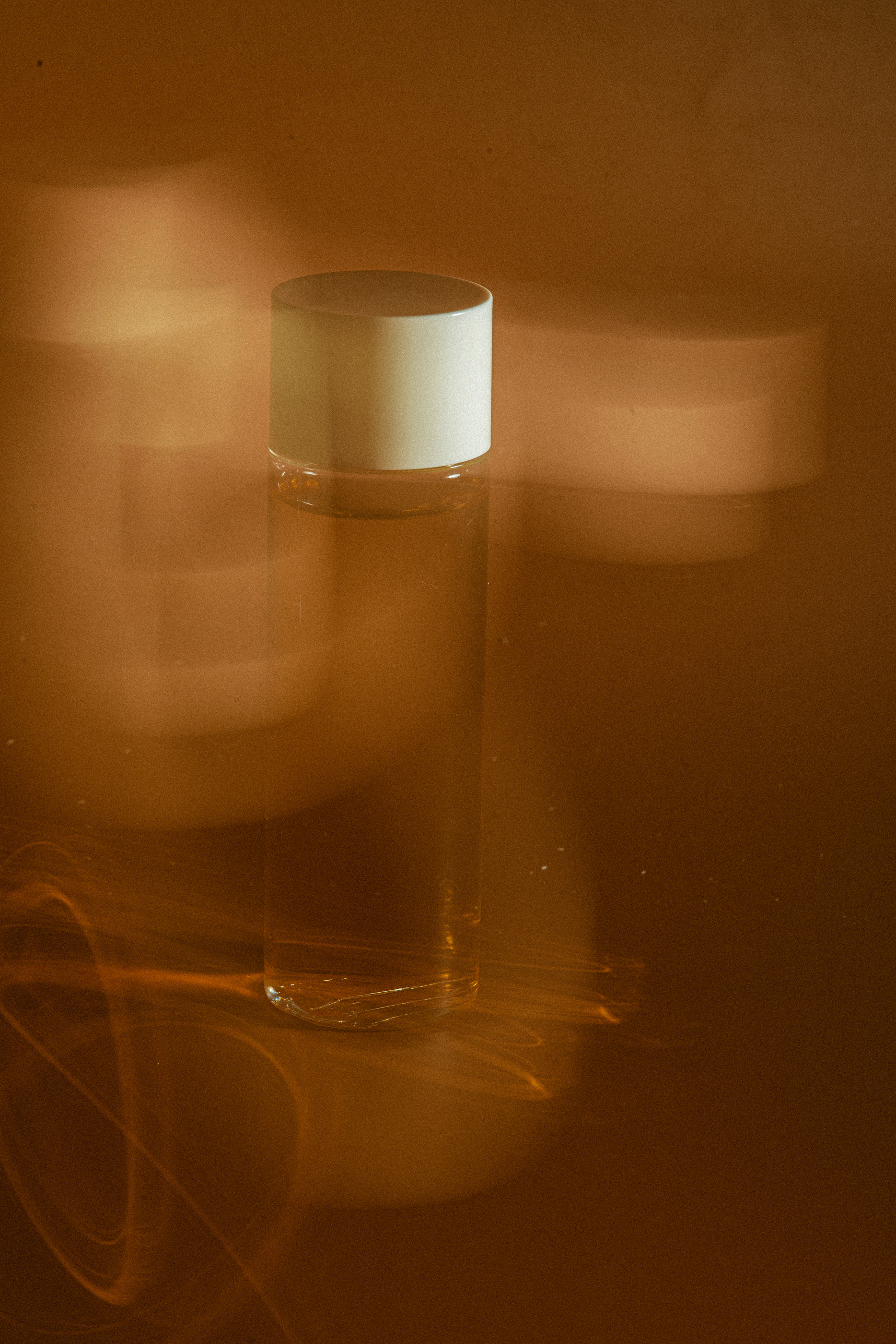 Blurry Cosmetic Bottle on Brown Background